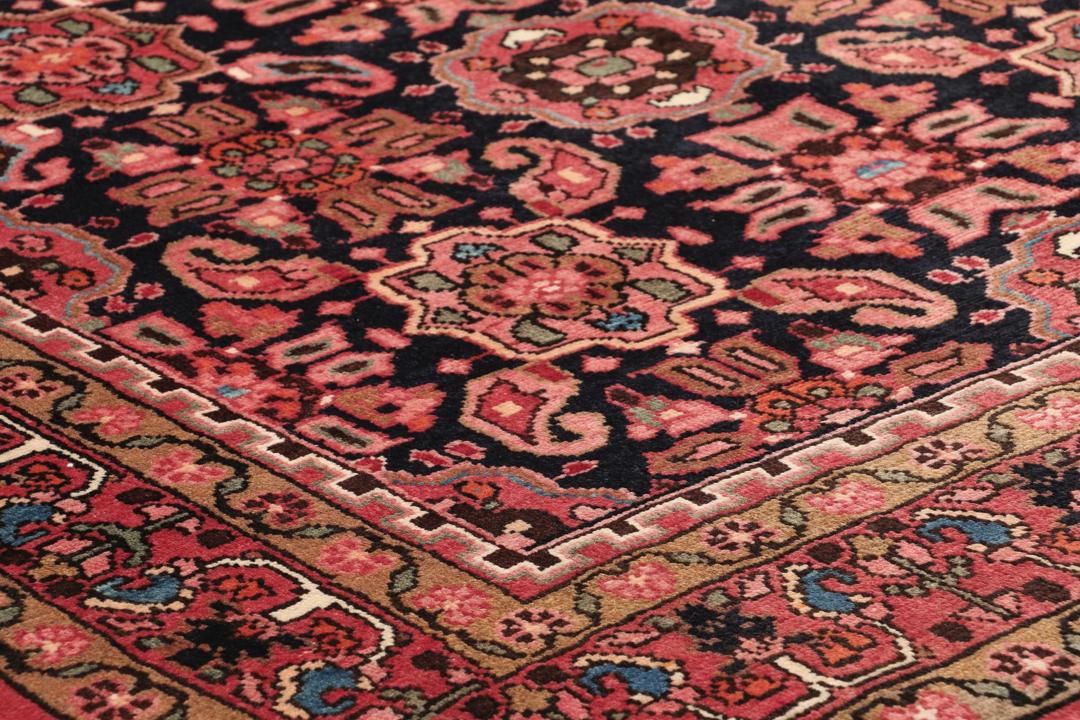 A rectangular hand-knotted Hamadan rug from the Middle East with a dark-red and black colour palette.