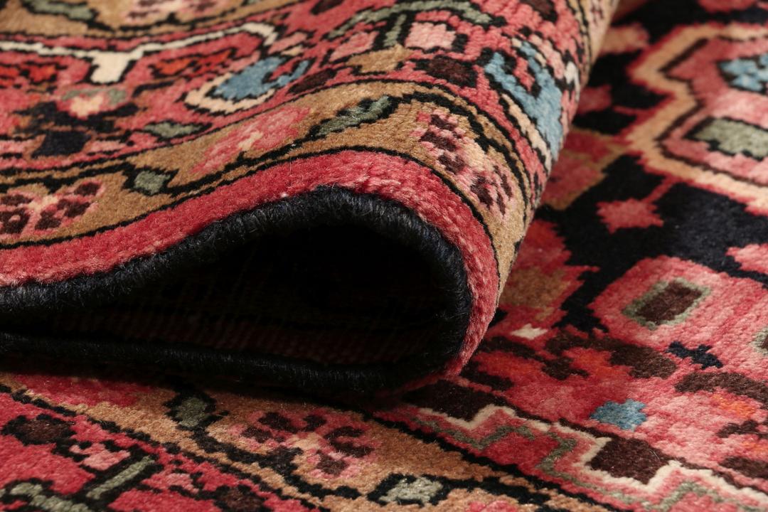 A rectangular hand-knotted Hamadan rug from the Middle East with a dark-red and black colour palette.