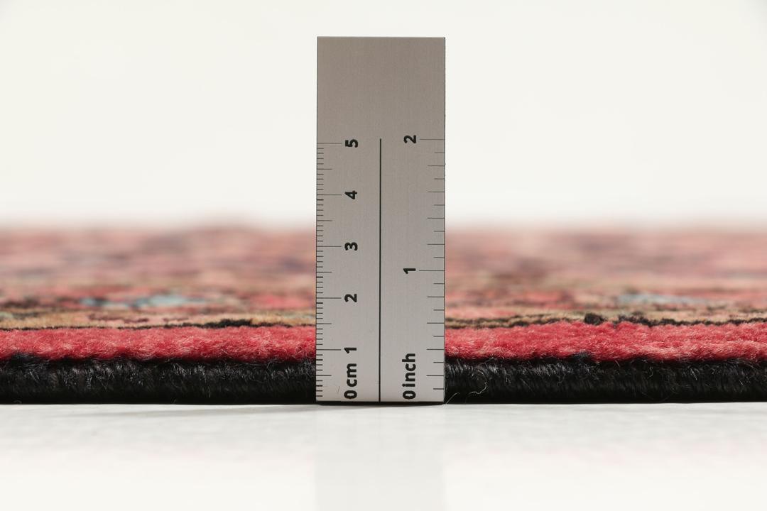 A rectangular hand-knotted Hamadan rug from the Middle East with a dark-red and black colour palette.