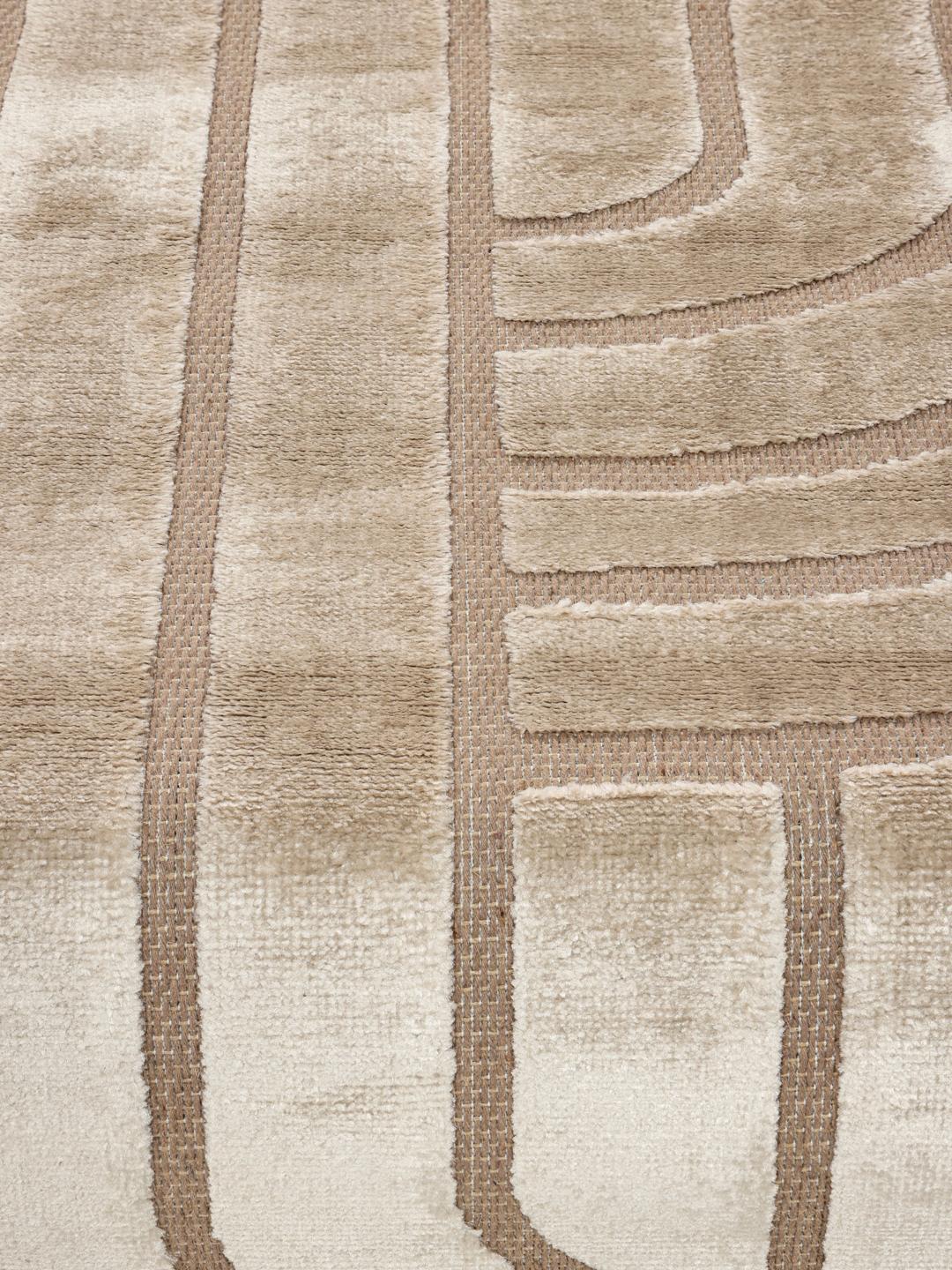 Onregelmatig beige vloerkleed met een modern hoog-laag geometrisch patroon