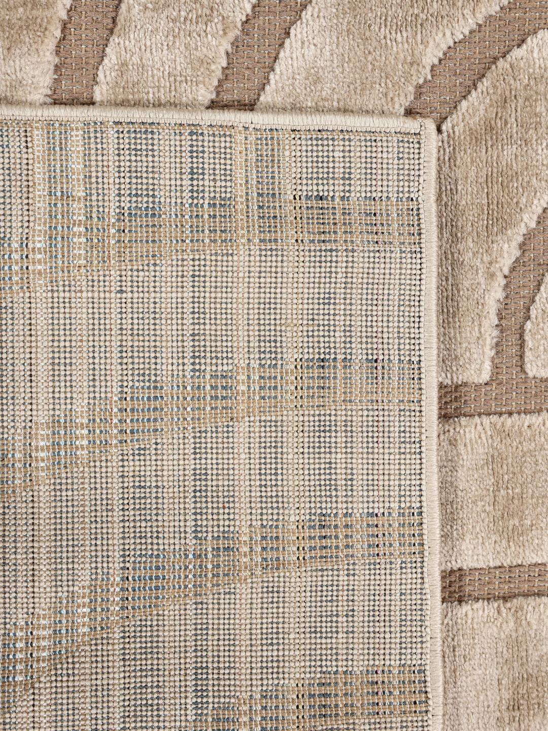 Onregelmatig beige vloerkleed met een modern hoog-laag geometrisch patroon