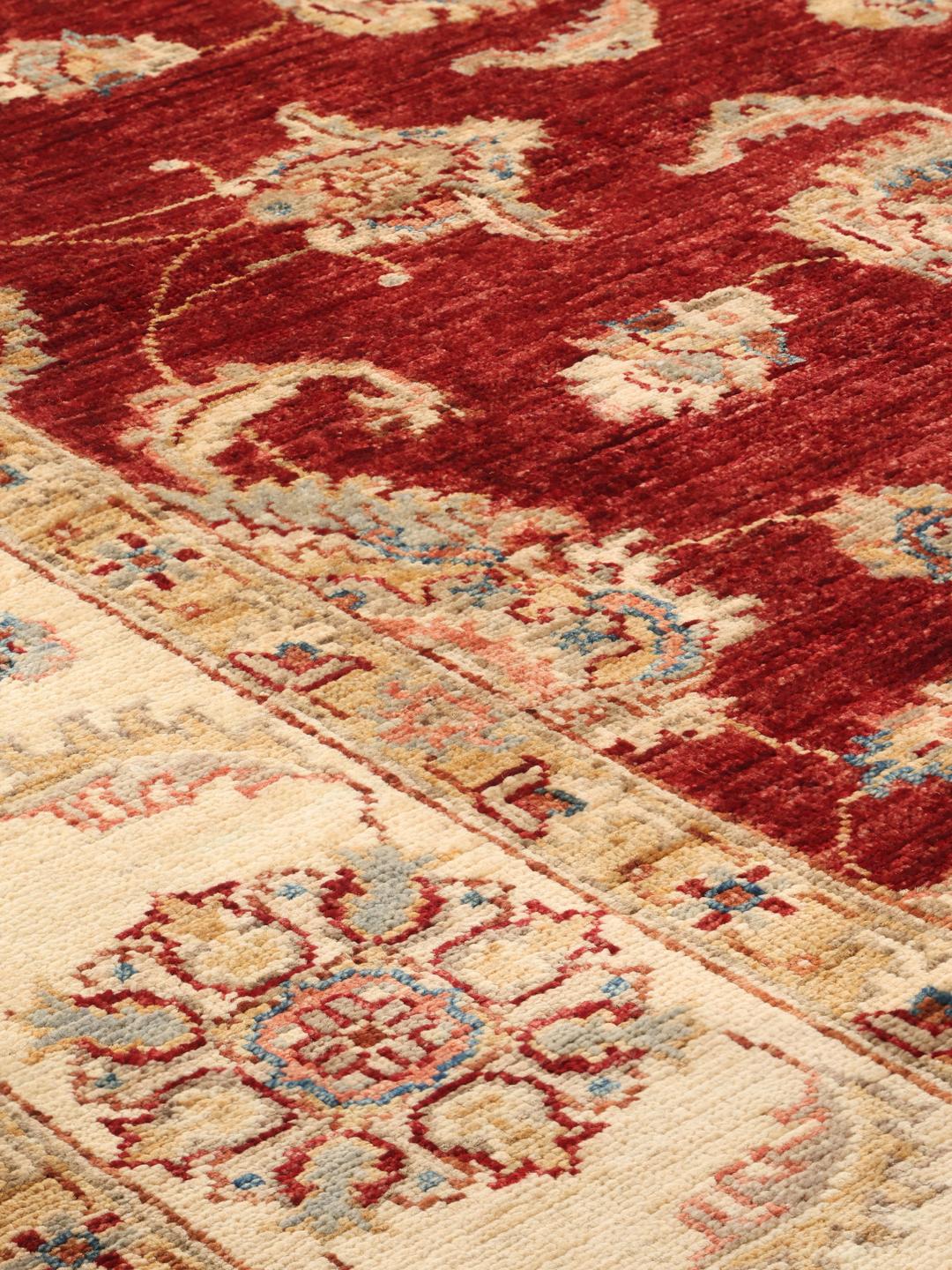 Covor Ziegler Fine înnodat manual din Pakistan, prezentând un câmp roșu și modele florale decorative.