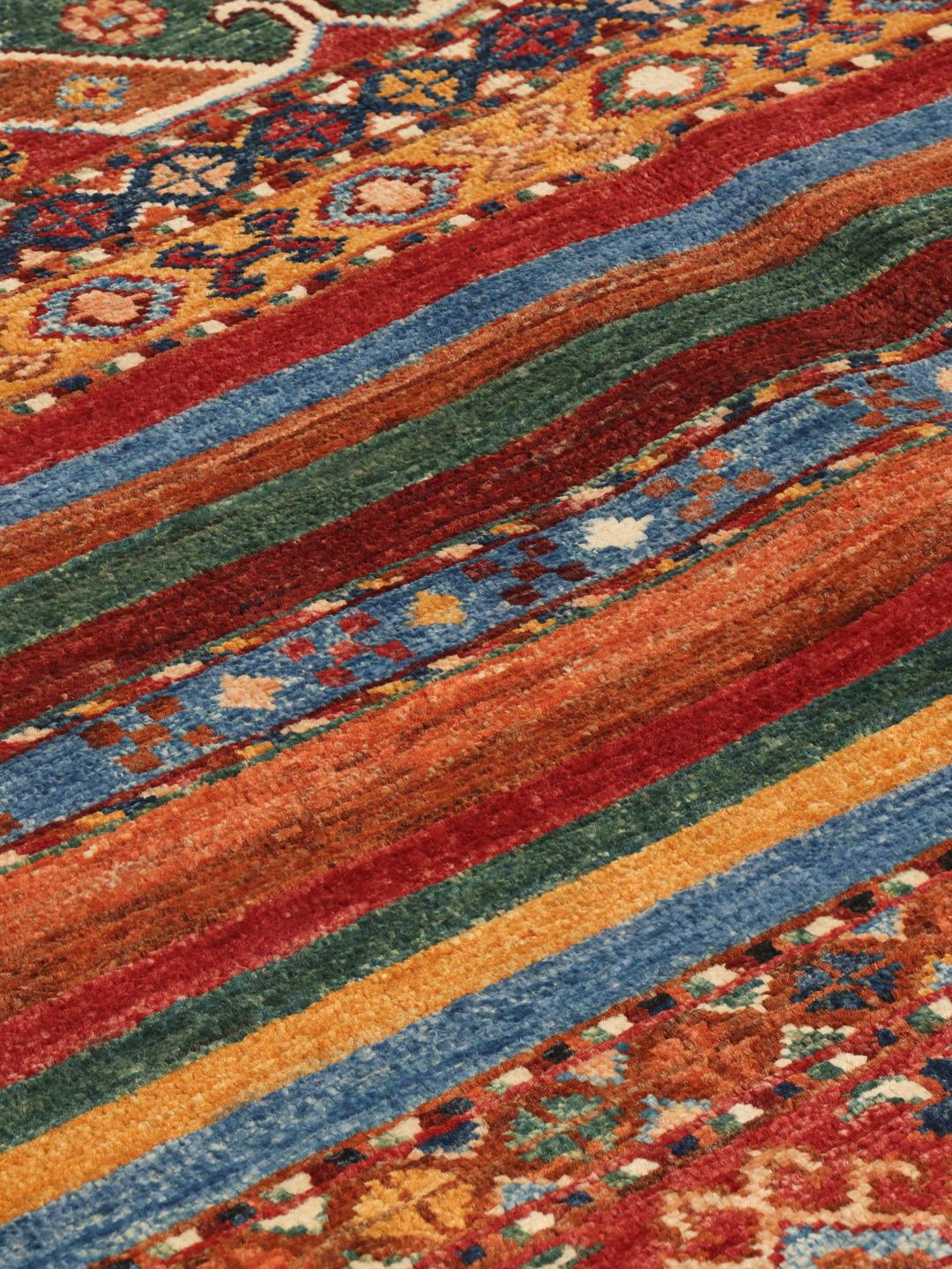 Handgeknoopt Afghaans tapijt met ingewikkelde geometrische patronen in rood, blauw en bruin.
