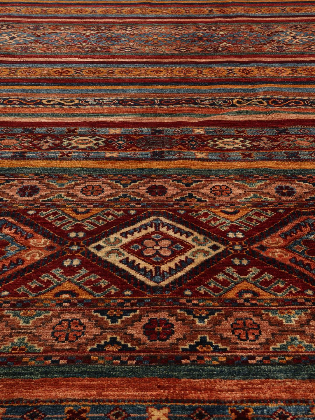Covor afgan înnodat manual în nuanțe de roșu și albastru cu un design geometric în dungi