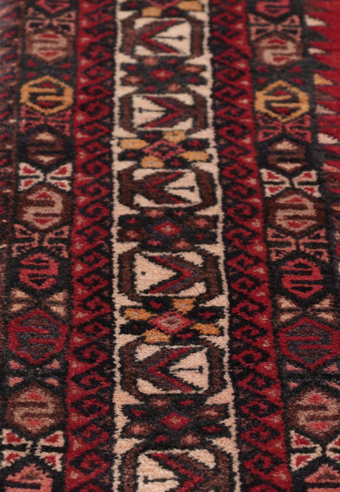 Et håndknyttet Afshar-tæppe fra Mellemøsten med et modigt rødt felt og geometriske motiver.
