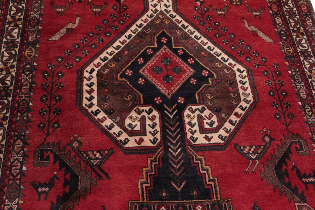 Et håndknyttet Afshar-tæppe fra Mellemøsten med et modigt rødt felt og geometriske motiver.