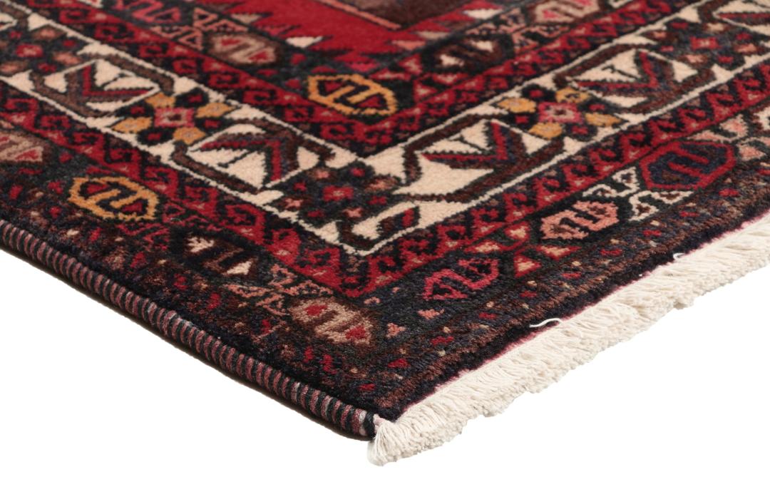 Et håndknyttet Afshar-tæppe fra Mellemøsten med et modigt rødt felt og geometriske motiver.