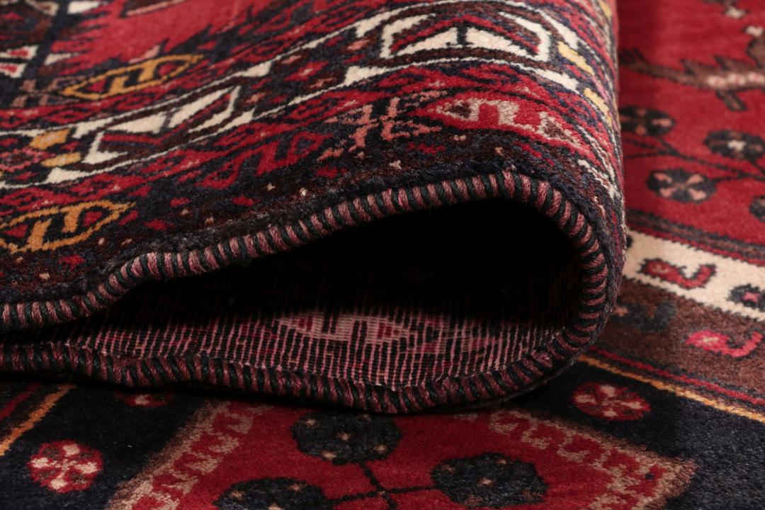 Et håndknyttet Afshar-tæppe fra Mellemøsten med et modigt rødt felt og geometriske motiver.