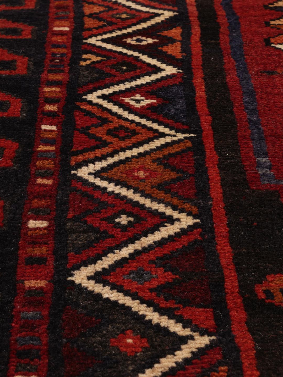 Hand-knotted Lori rug with red and black geometric tribal patterns from the Middle East