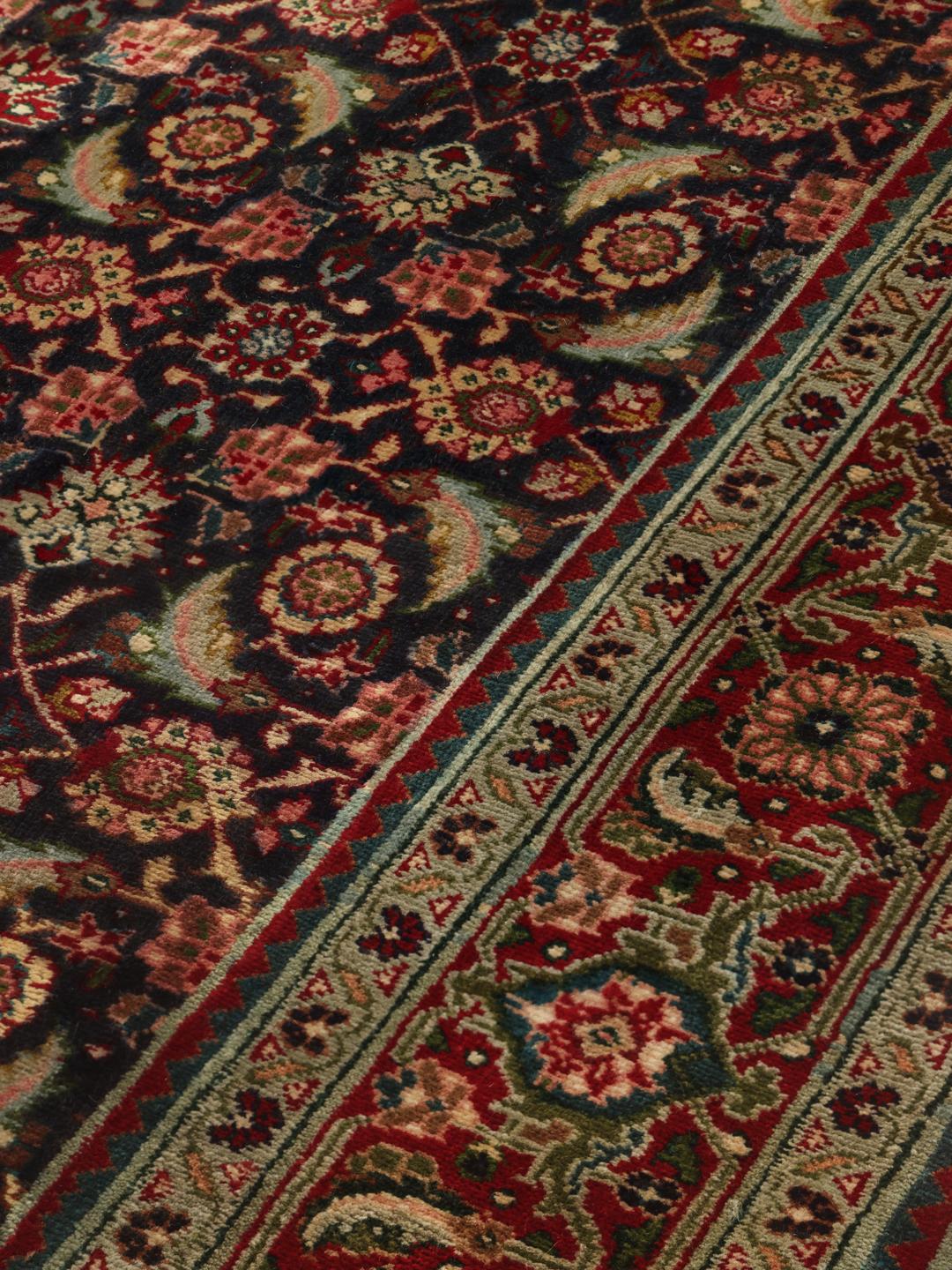 Et unikt håndknyttet Tabriz-tæppe fra Mellemøsten i mørkeblå og røde nuancer