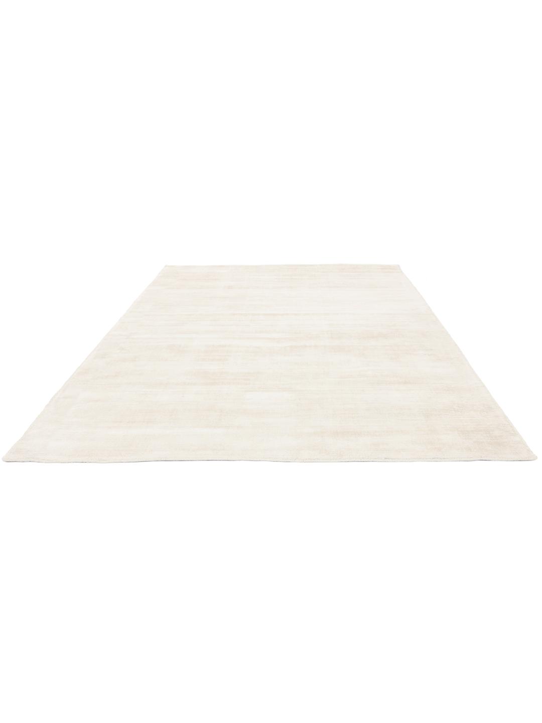 Un tapis blanc ivoire doux avec une surface subtile et tactile.