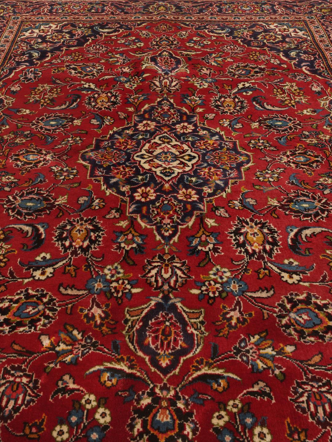 A hand-knotted Keshan rug in red and blue tones from the Middle East.