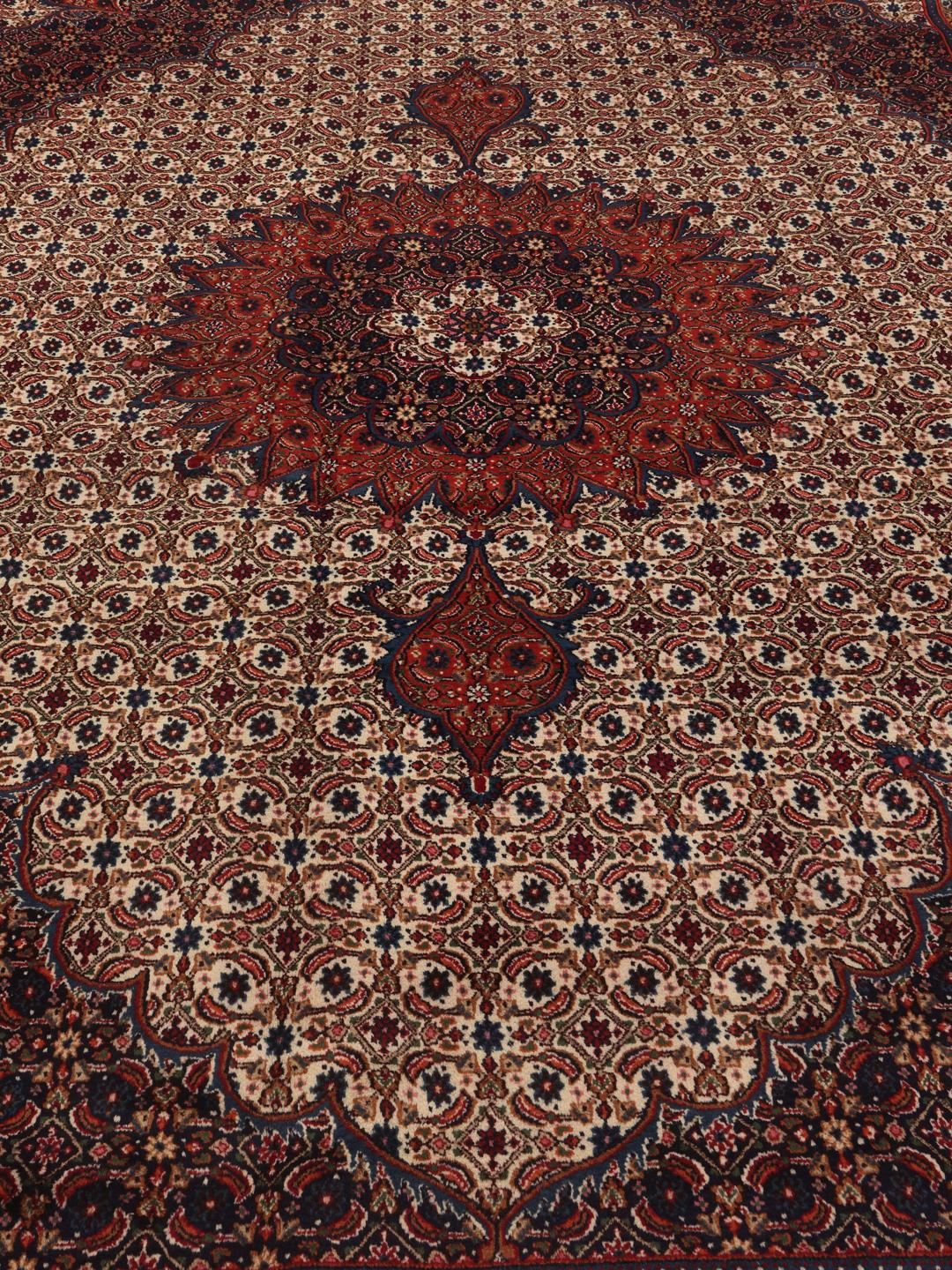 A hand-knotted Moud rug from the Middle East in dark-red and blue tones.
