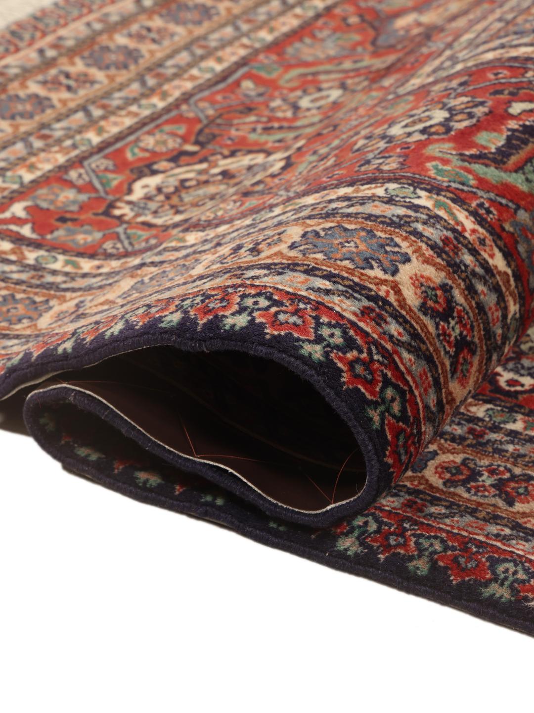 A large Moud rug from the Middle East featuring a dark-red field with a central medallion.
