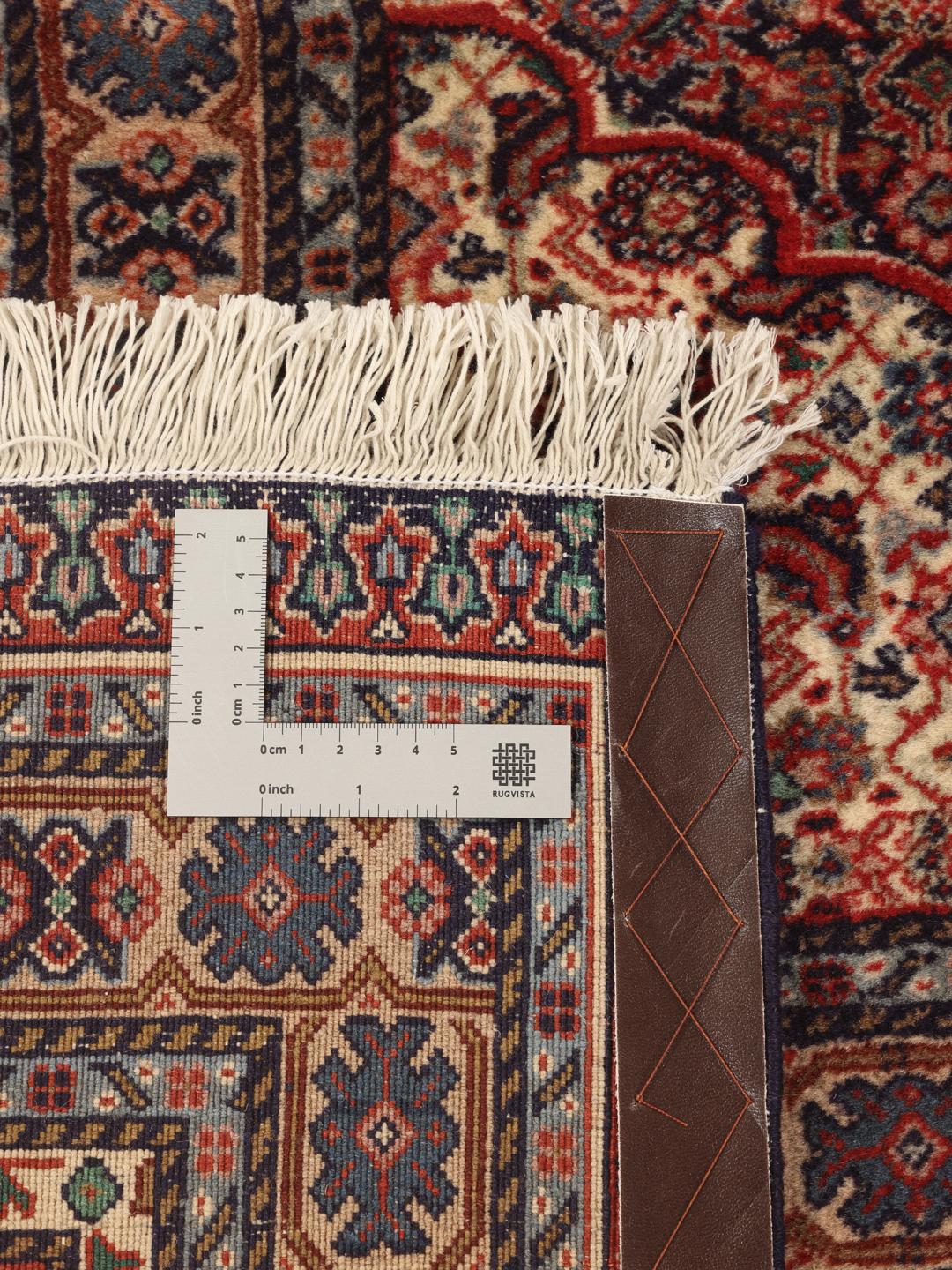 A large Moud rug from the Middle East featuring a dark-red field with a central medallion.
