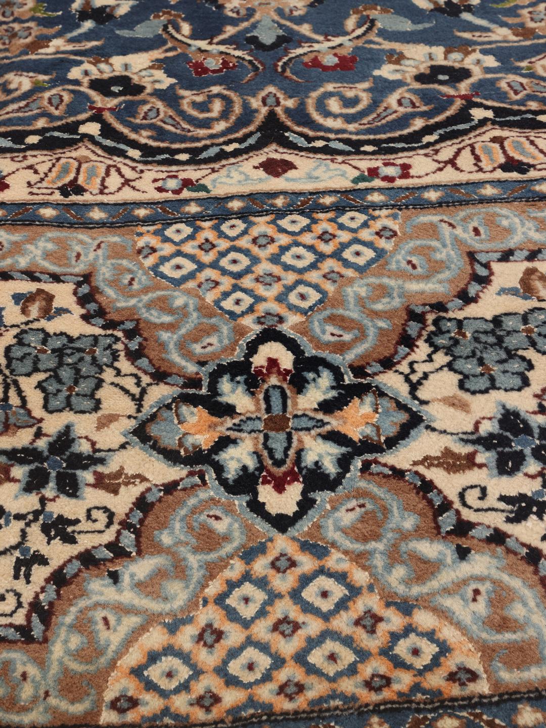 Hand-knotted Nain Fine 9La rug with a central medallion and floral motifs in blue and cream