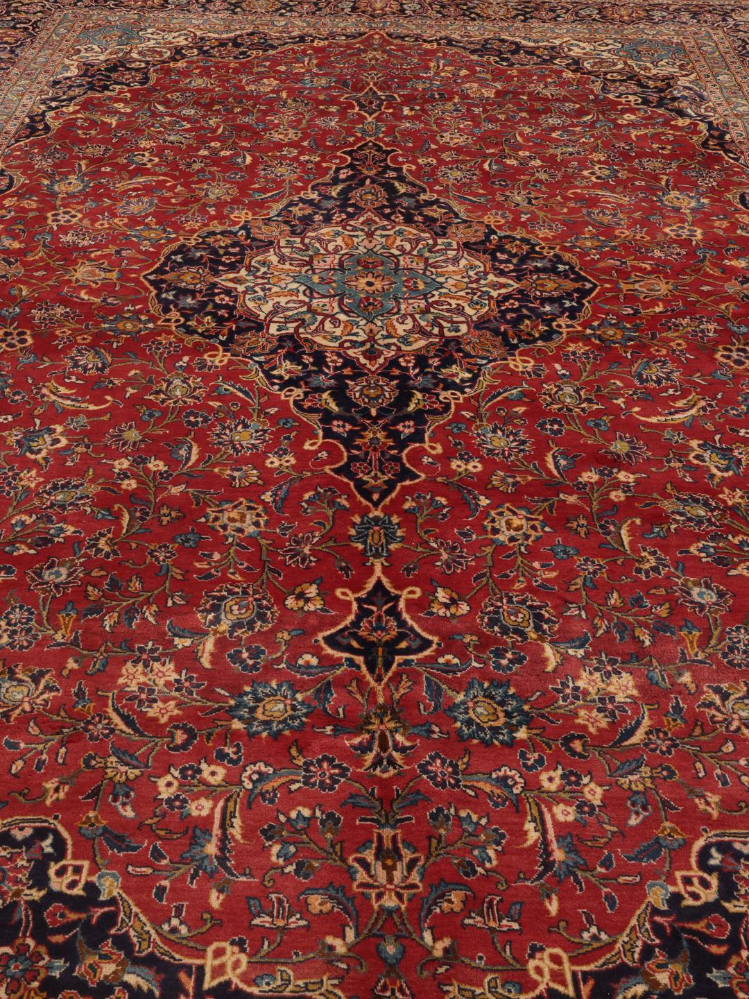 Handgeknoopt Keshan tapijt uit het Midden-Oosten met een levendig rood en donkerblauw bloemmotief.