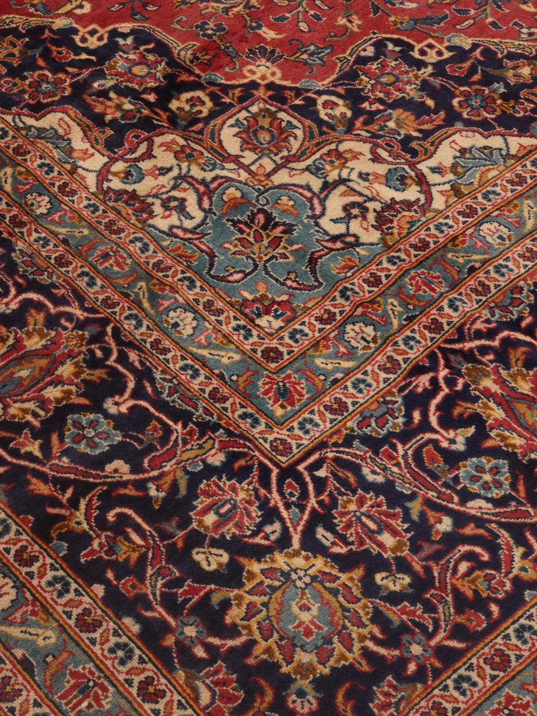Handgeknoopt Keshan tapijt uit het Midden-Oosten met een levendig rood en donkerblauw bloemmotief.