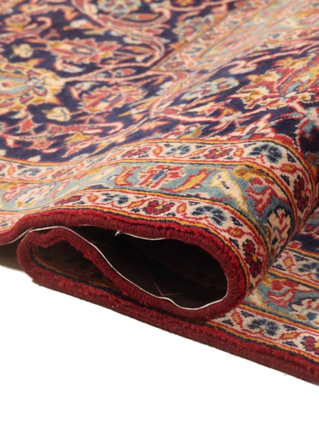 Handgeknoopt Keshan tapijt uit het Midden-Oosten met een levendig rood en donkerblauw bloemmotief.