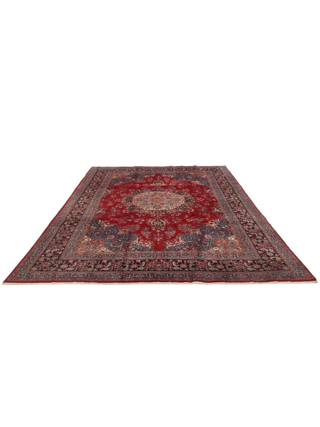 A hand-knotted Mashad rug from the Middle East in deep red and blue tones.