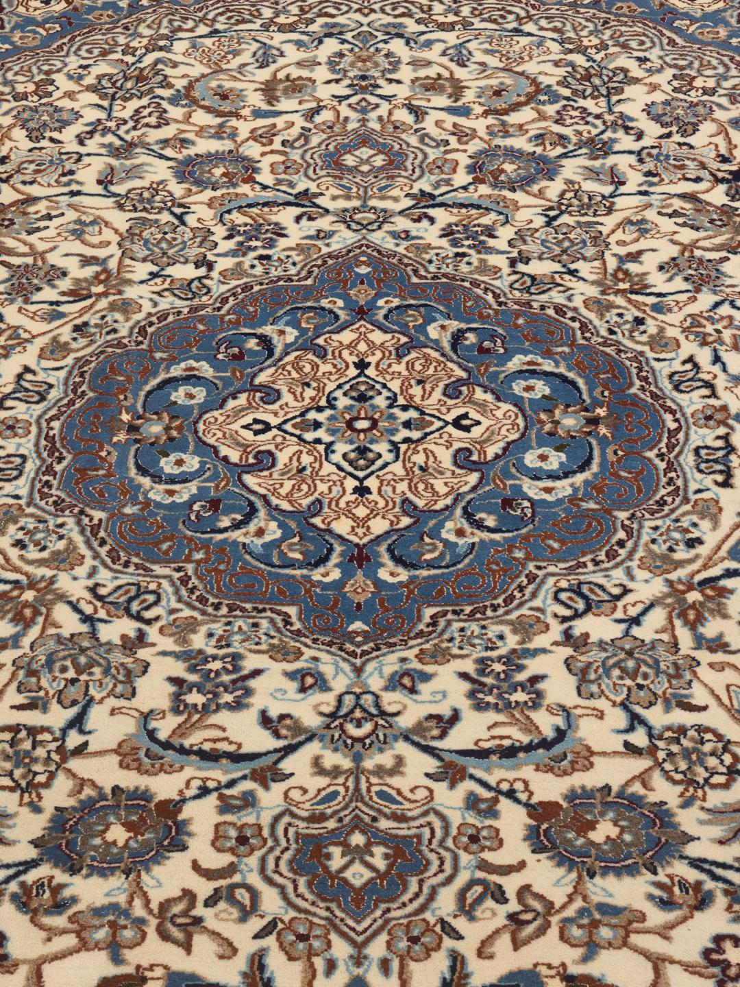 A rectangular Nain rug from the Middle East featuring a floral pattern in beige and blue.