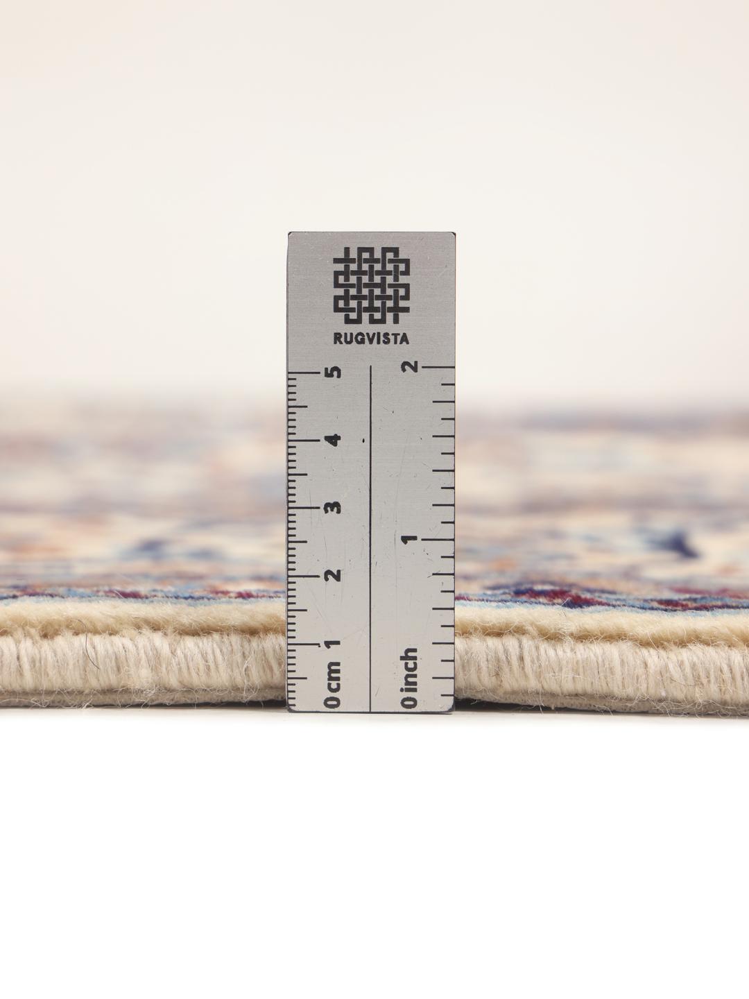 A rectangular Nain rug from the Middle East featuring a floral pattern in beige and blue.
