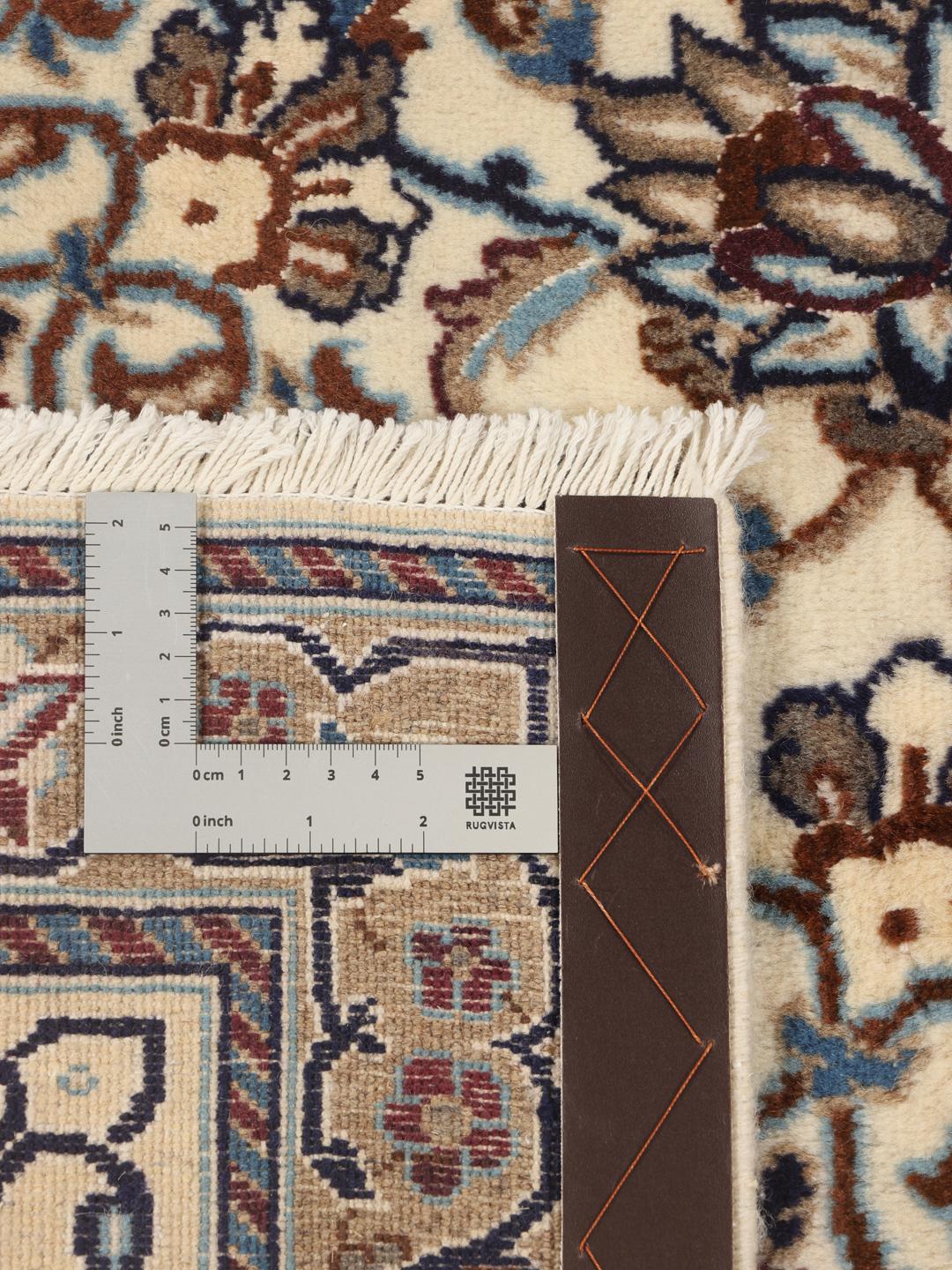 A rectangular Nain rug from the Middle East featuring a floral pattern in beige and blue.