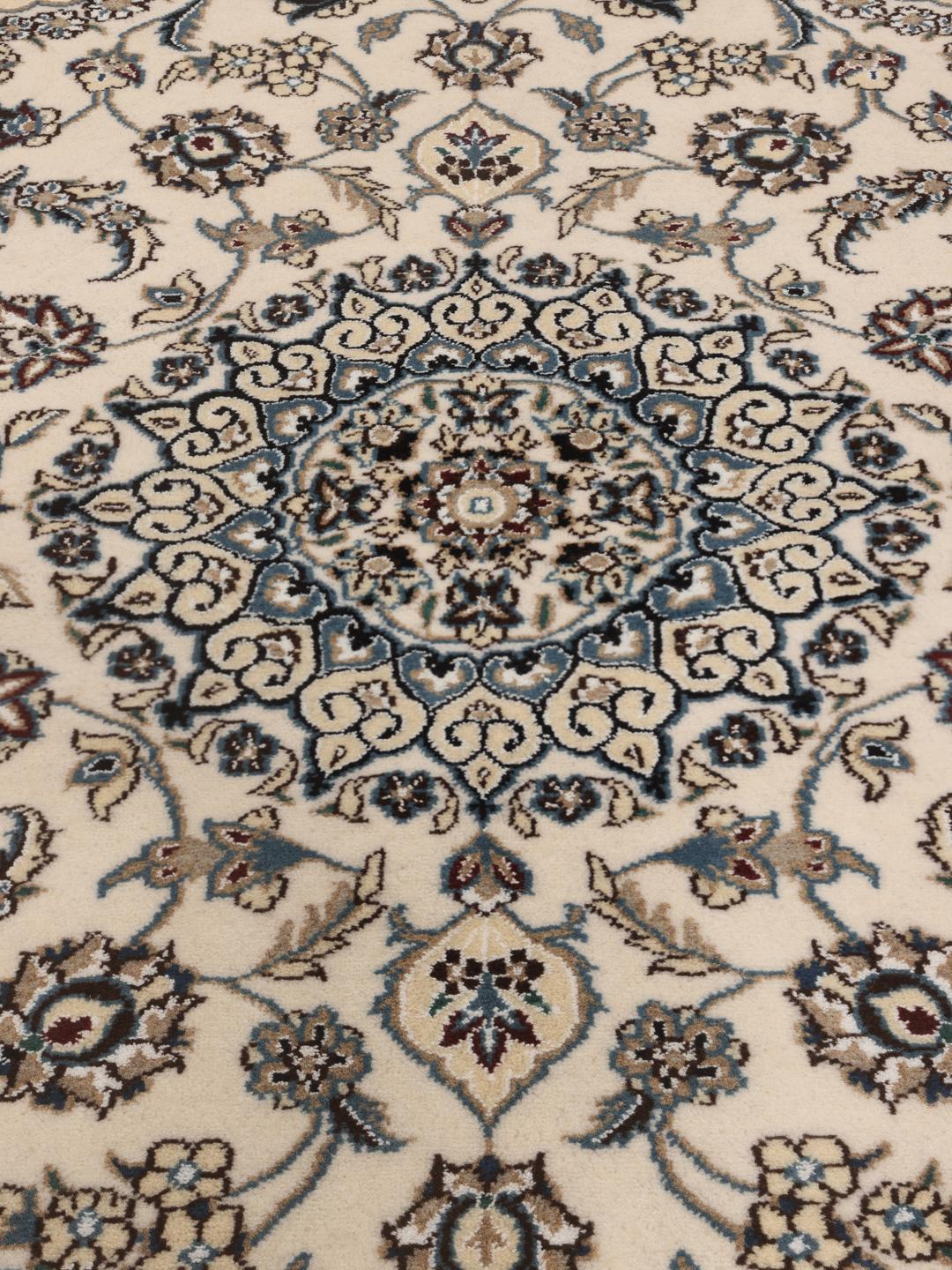 Een handgeknoopt Nain-tapijt uit het Midden-Oosten met een beige achtergrond en blauwe bloemmotieven