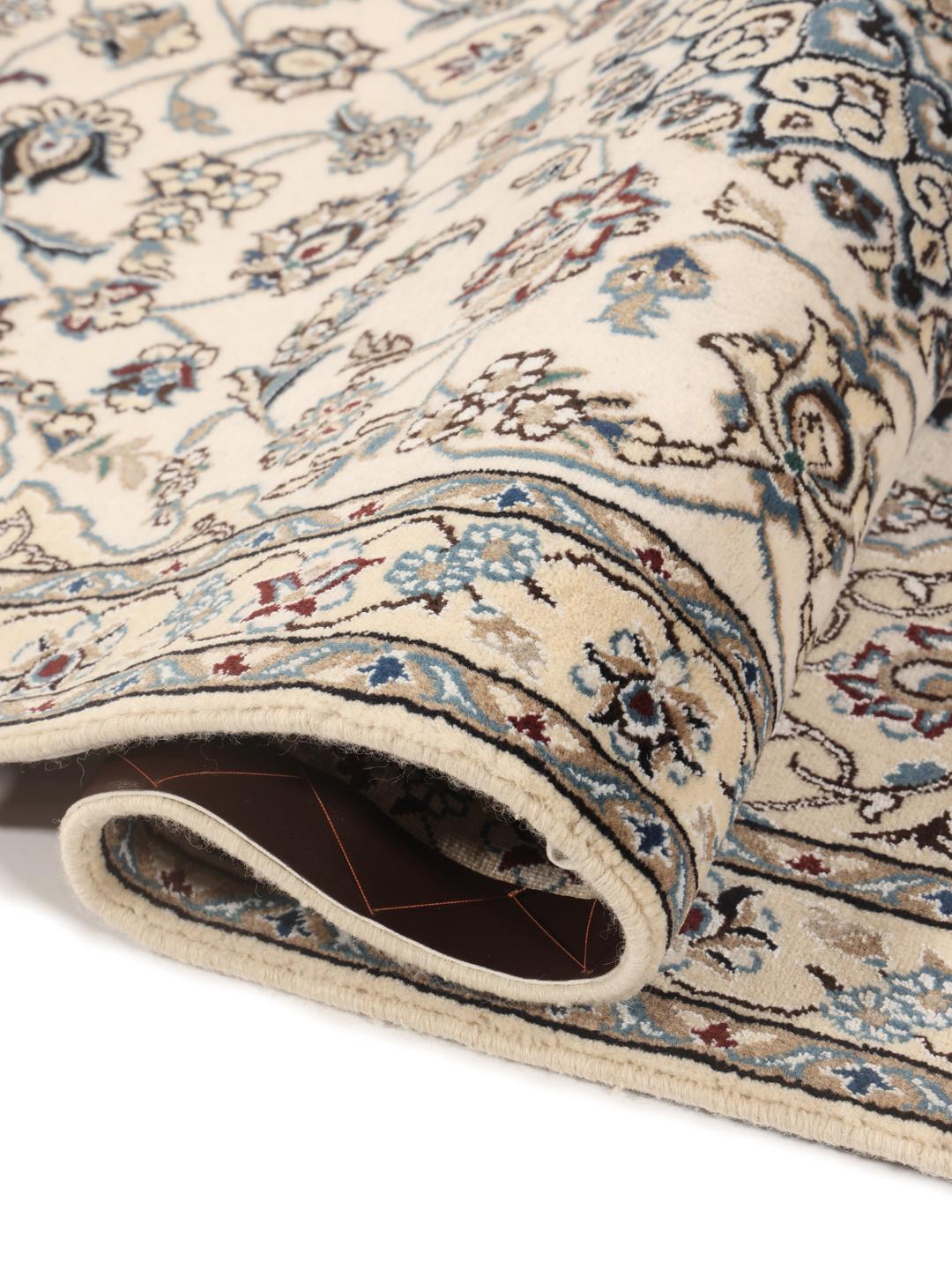 Een handgeknoopt Nain-tapijt uit het Midden-Oosten met een beige achtergrond en blauwe bloemmotieven