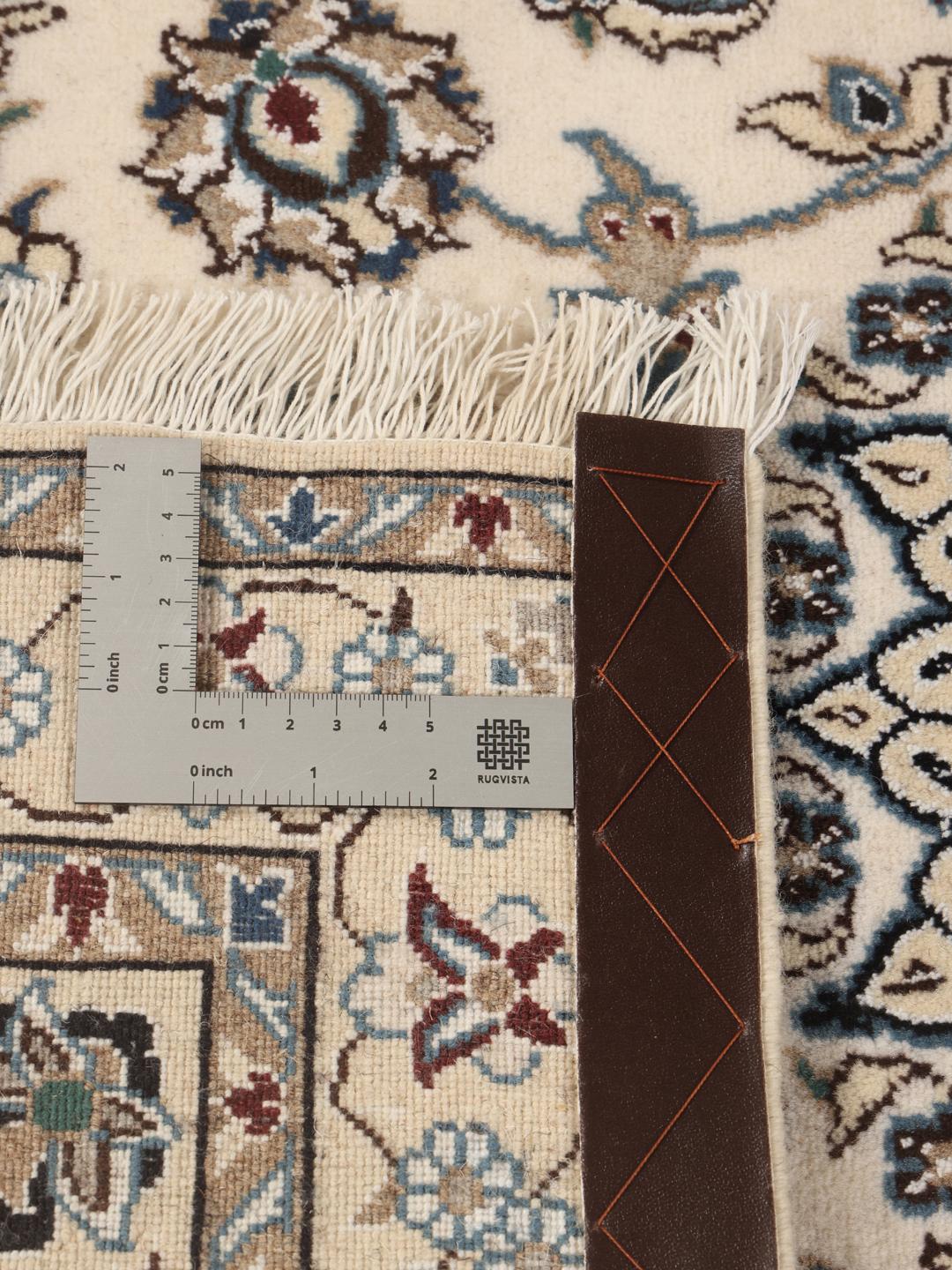 Een handgeknoopt Nain-tapijt uit het Midden-Oosten met een beige achtergrond en blauwe bloemmotieven