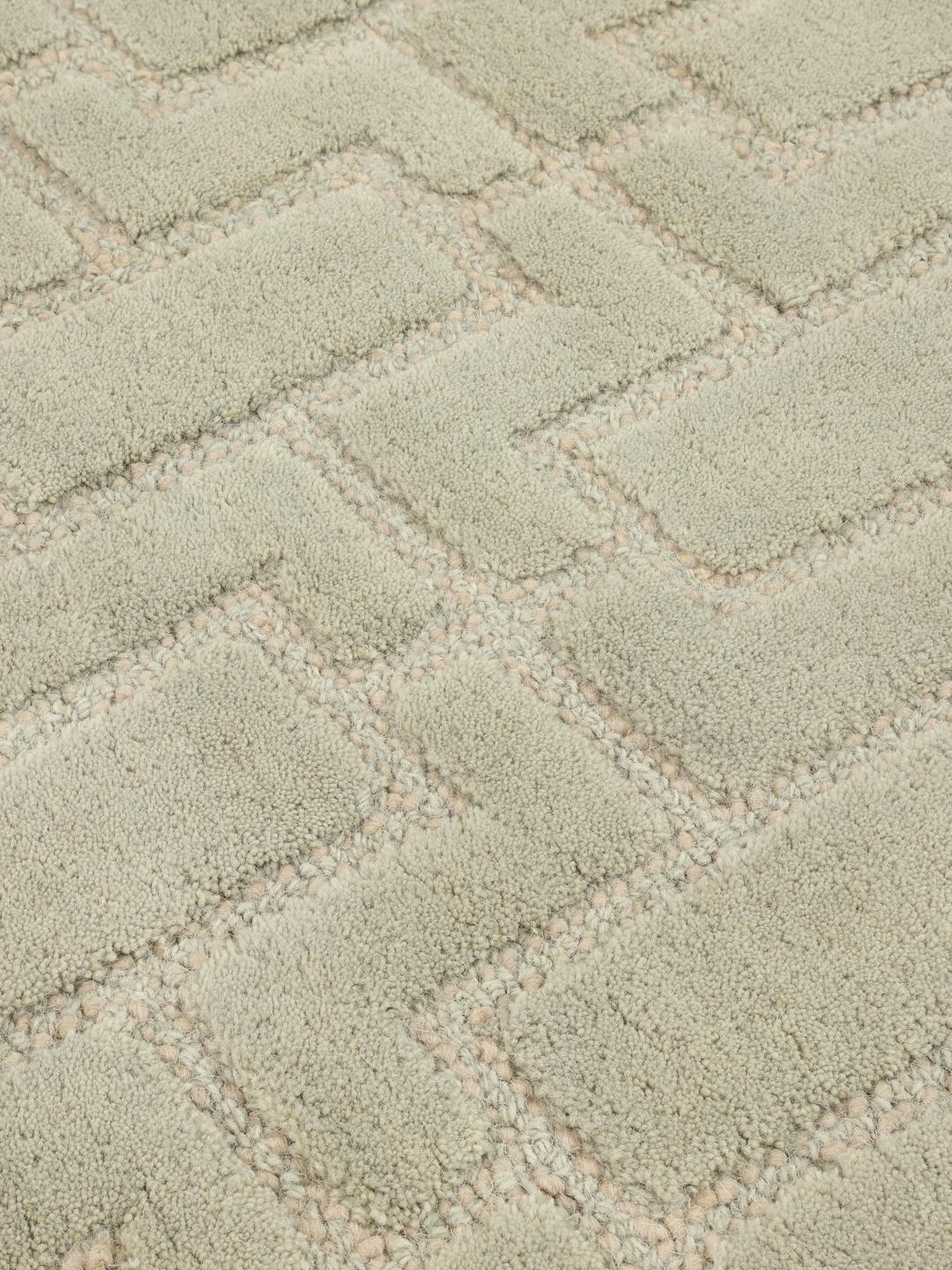Green rug with a geometric high and low pile texture
