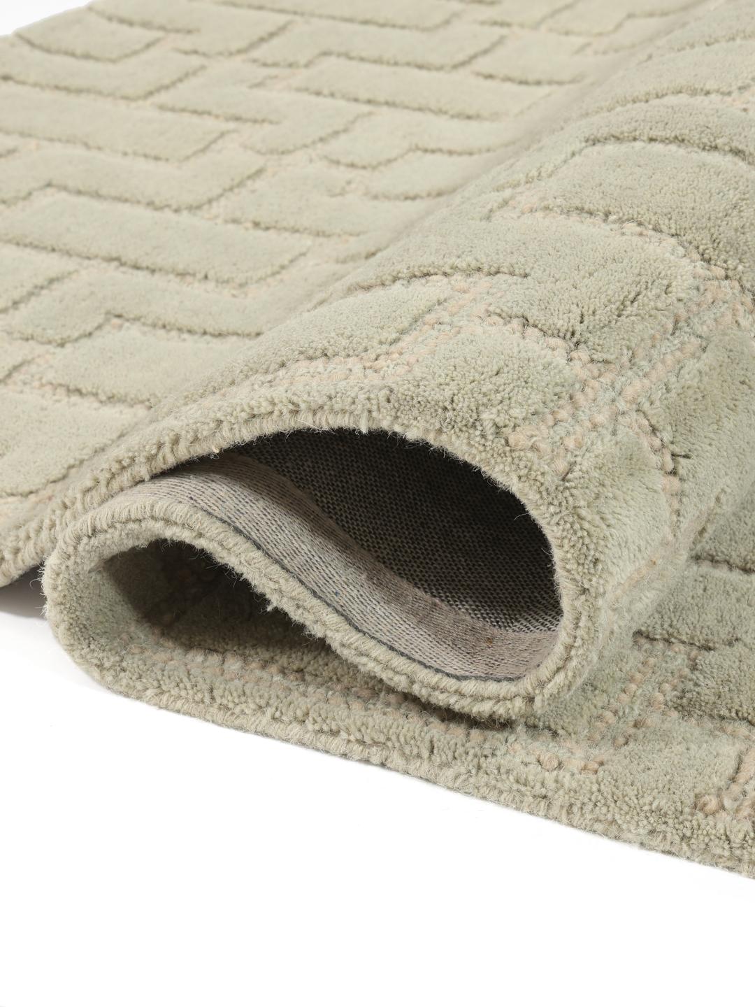 Green rug with a geometric high and low pile texture