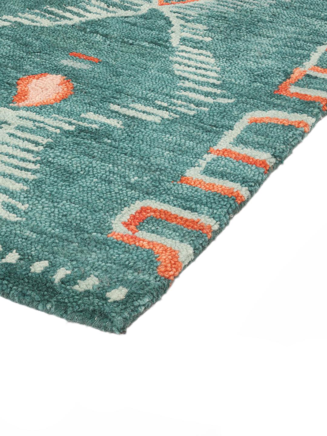 Tapis en laine verte aux motifs tribaux