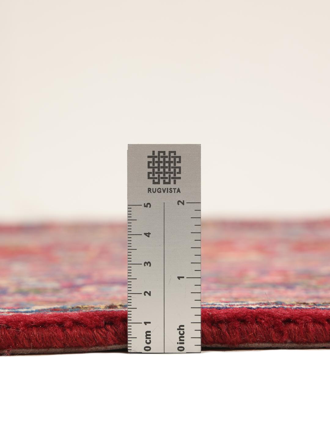 A hand-knotted Mashad rug from the Middle East in shades of red and blue.