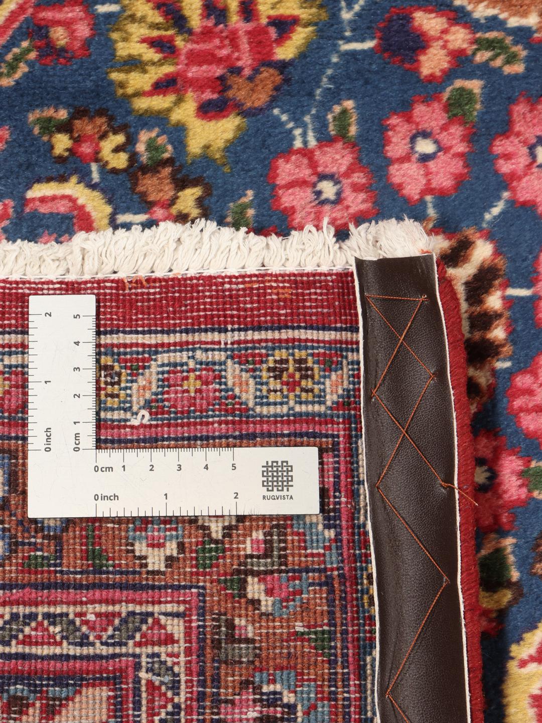A hand-knotted Mashad rug from the Middle East in shades of red and blue.