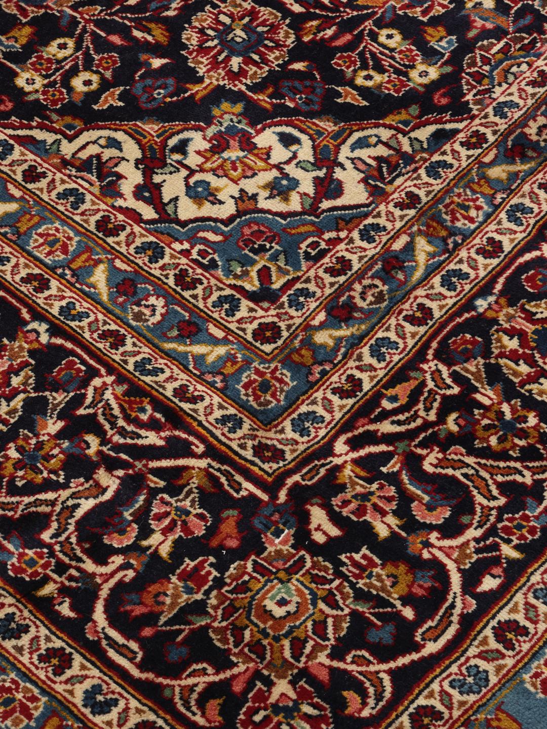 A hand-knotted Keshan rug from the Middle East in deep red and blue tones
