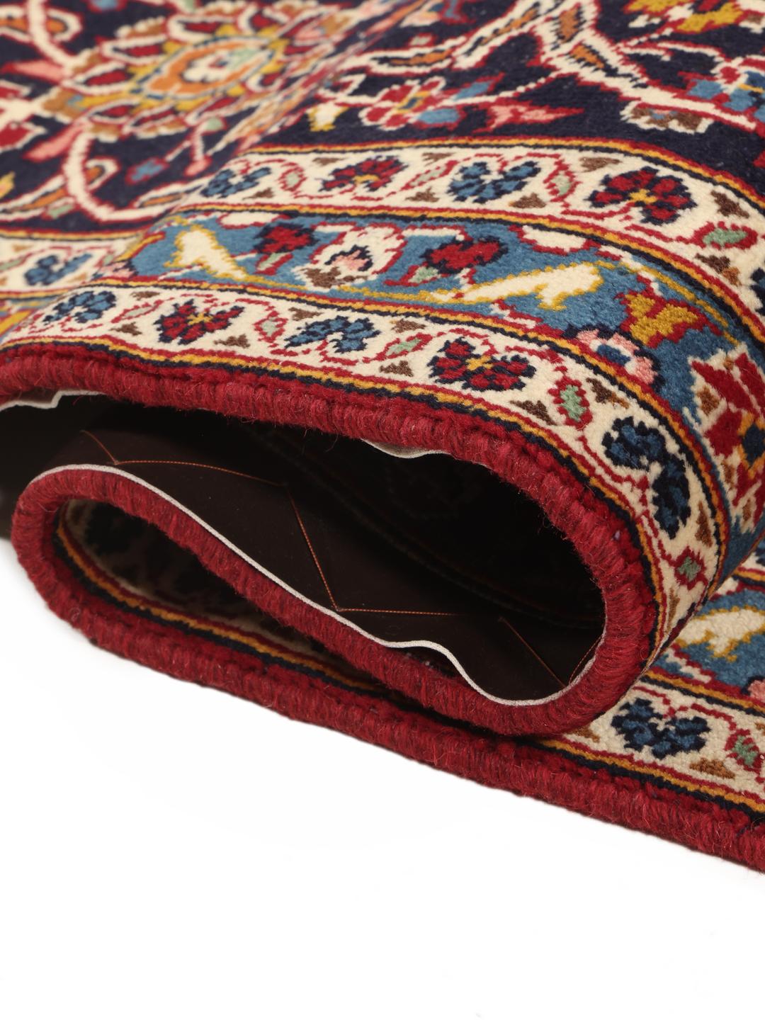 A hand-knotted Keshan rug from the Middle East in deep red and blue tones
