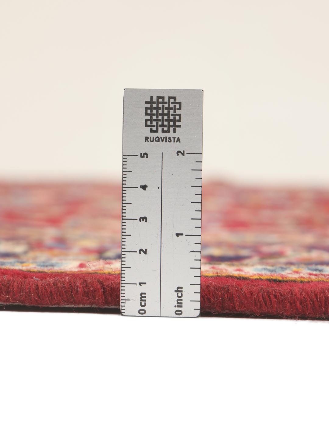 A hand-knotted Middle Eastern Keshan rug with a red and blue floral medallion design.