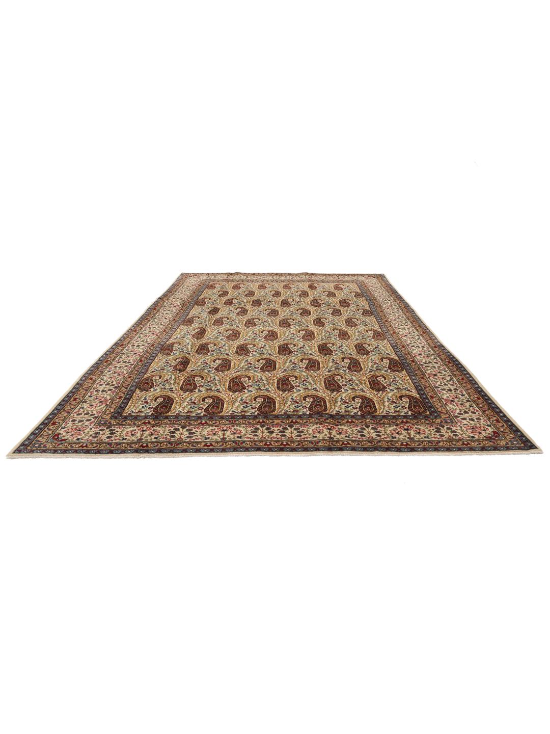 Een handgeknoopt Kerman tapijt uit het Midden-Oosten met een beige veld en rode en blauwe paisley-motieven.