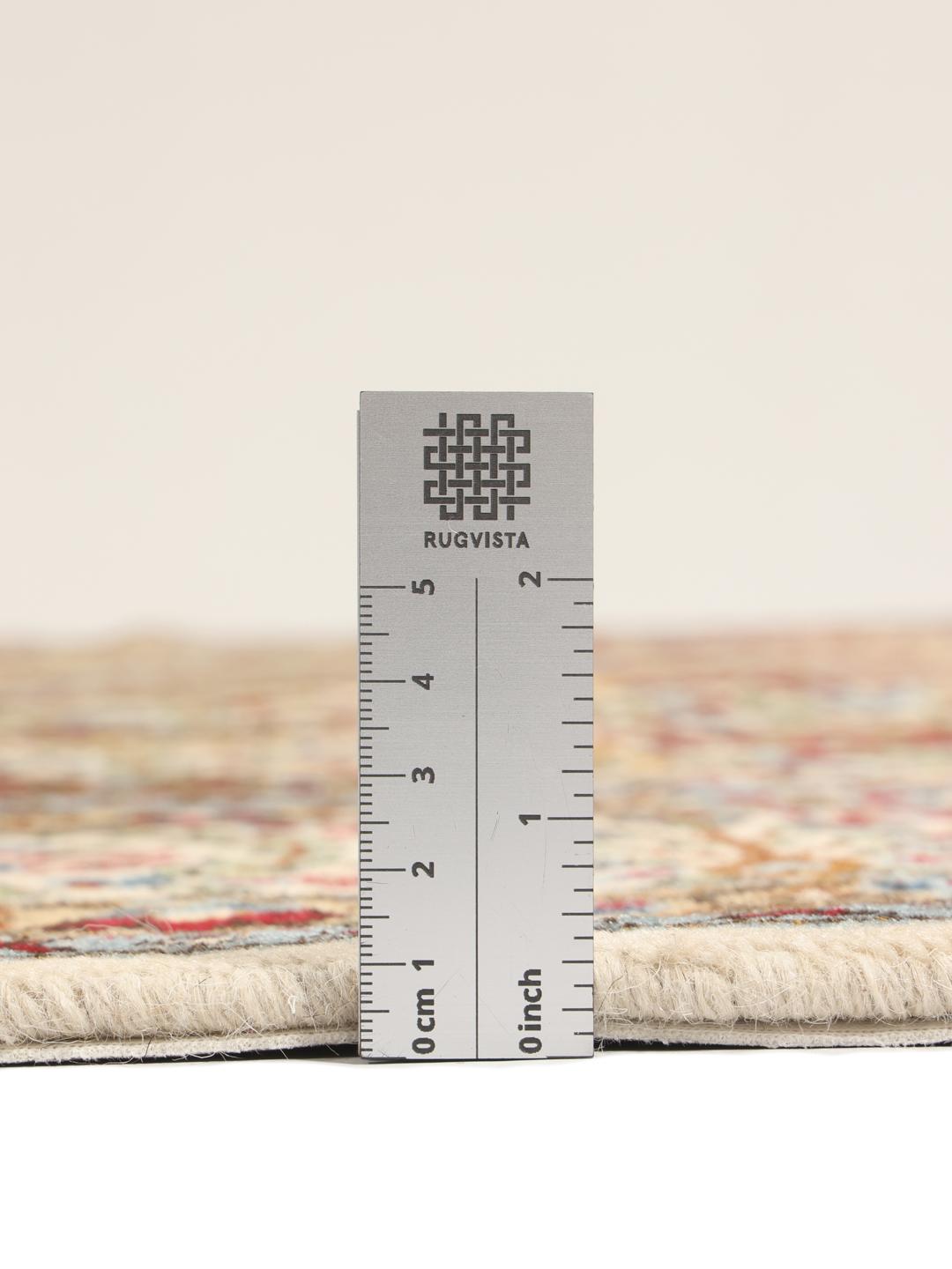 Een handgeknoopt Kerman tapijt uit het Midden-Oosten met een beige veld en rode en blauwe paisley-motieven.