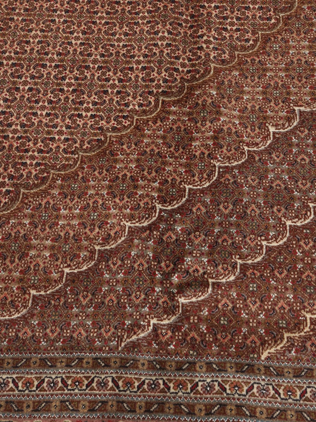 Een groot, handgeknoopt Tabriz-tapijt met een bruin veld en een ingewikkeld centraal medaillon.