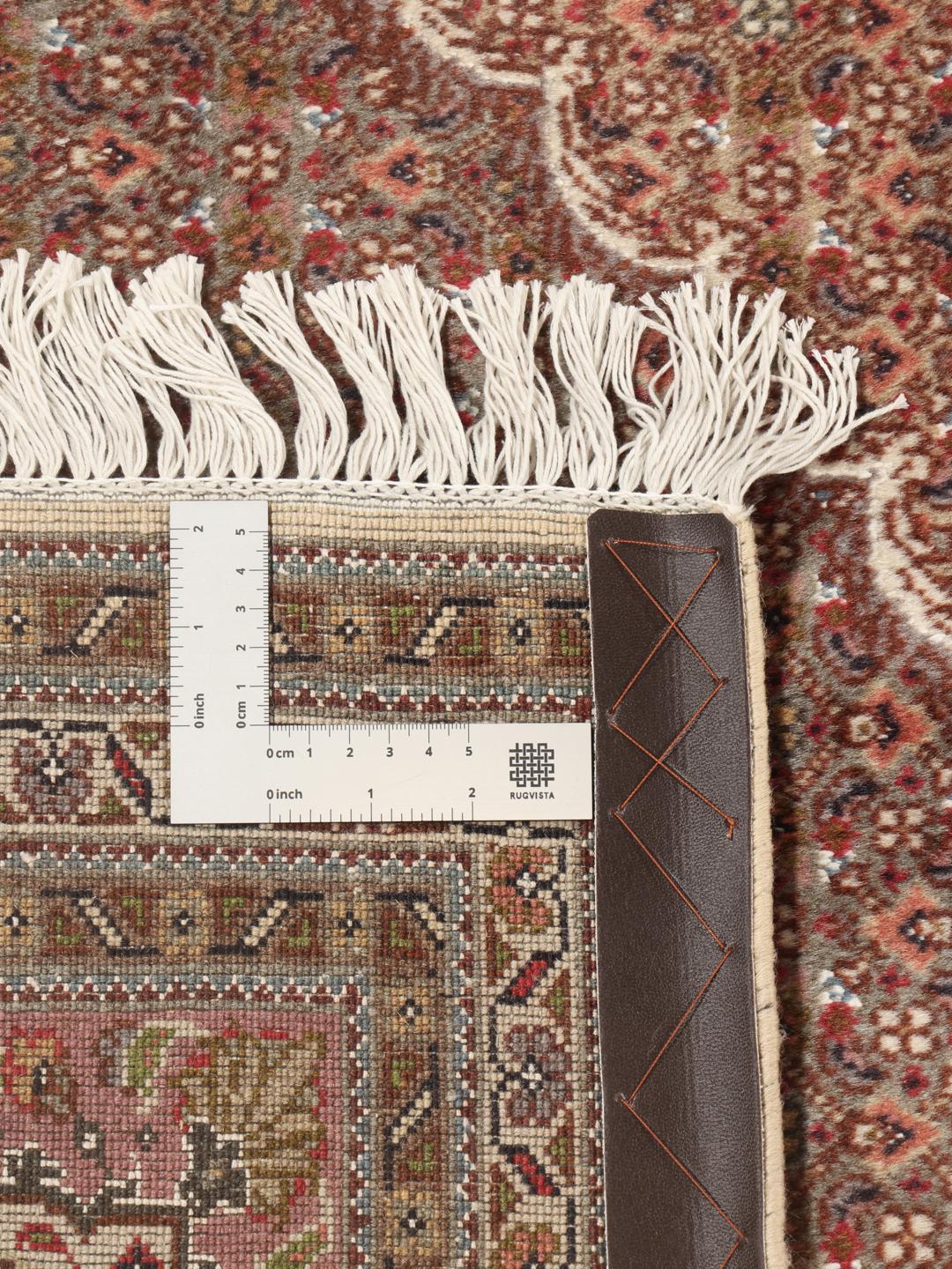 Een groot, handgeknoopt Tabriz-tapijt met een bruin veld en een ingewikkeld centraal medaillon.