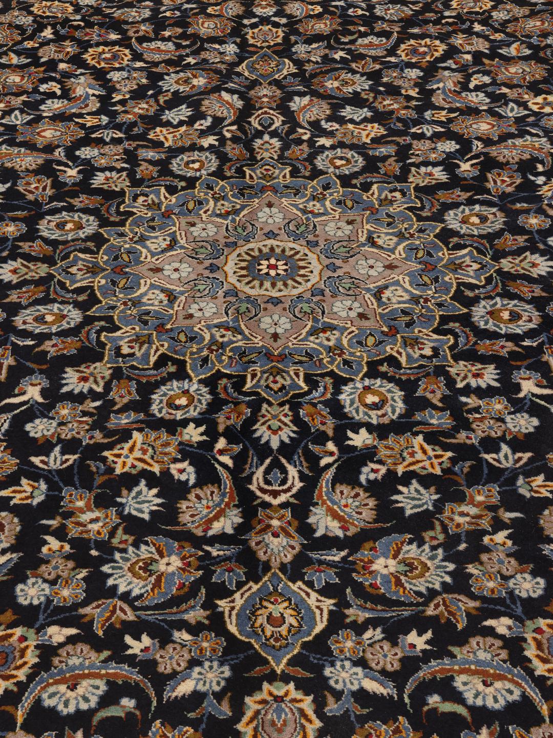 A large, hand-knotted Keshan rug from the Middle East in dark-blue with a central medallion.