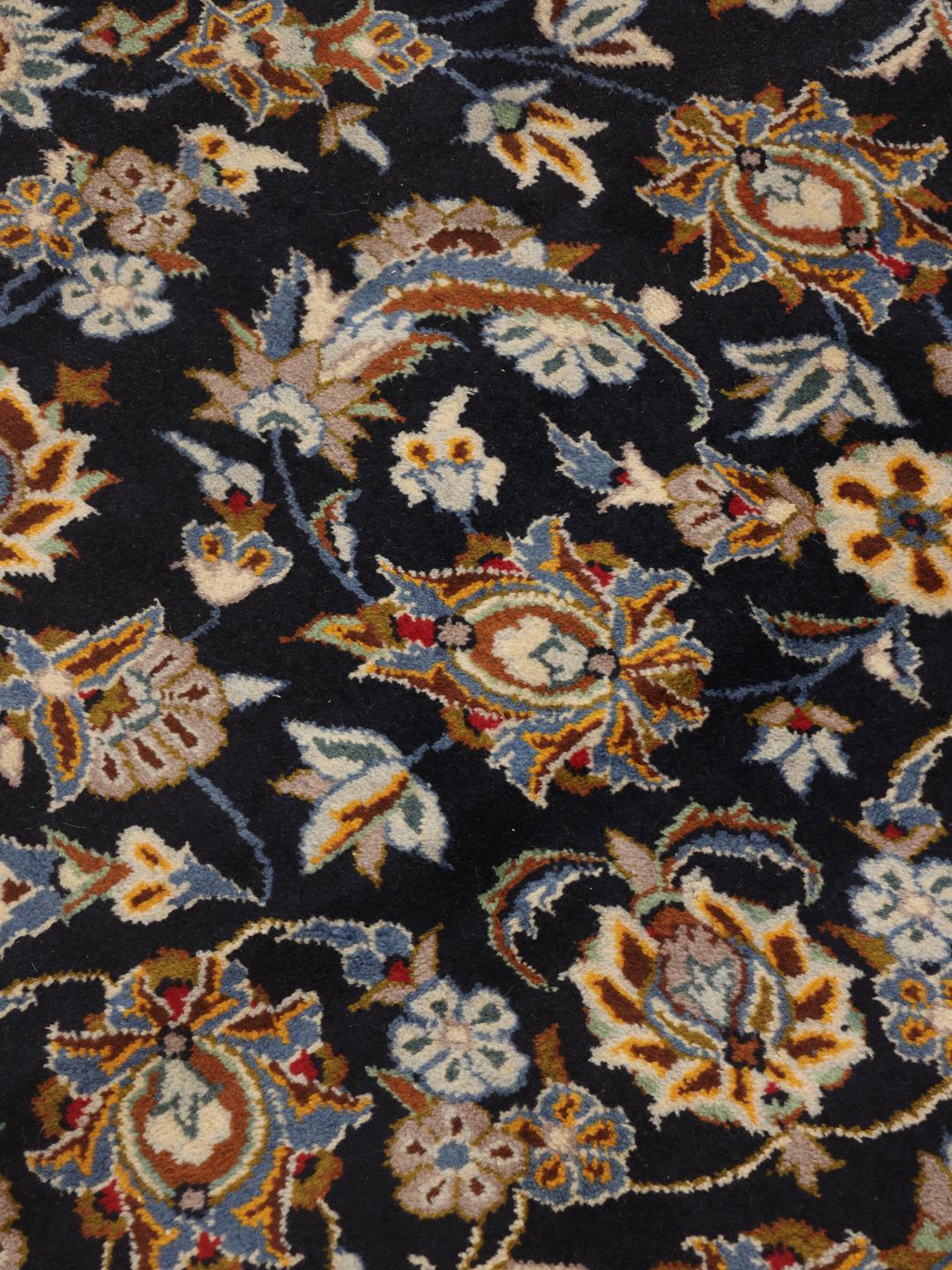 A large, hand-knotted Keshan rug from the Middle East in dark-blue with a central medallion.