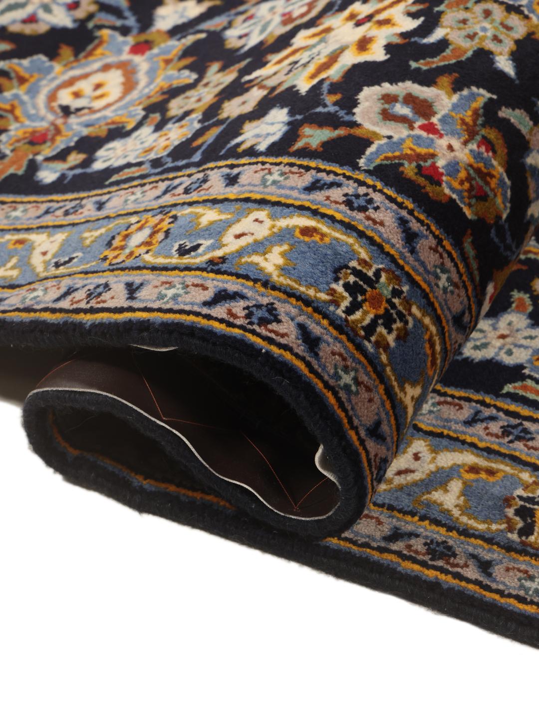 A large, hand-knotted Keshan rug from the Middle East in dark-blue with a central medallion.