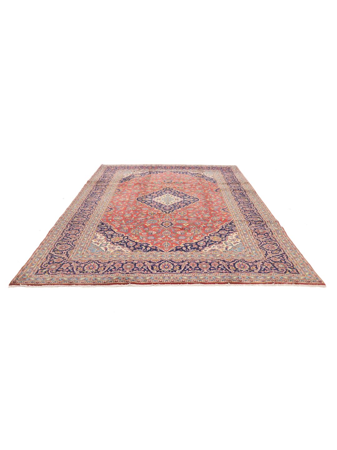 A hand-knotted Keshan rug from the Middle East with a red field and traditional floral motifs.