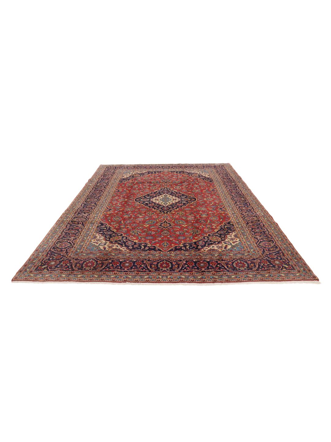 A hand-knotted Keshan rug from the Middle East with a red field and traditional floral motifs.