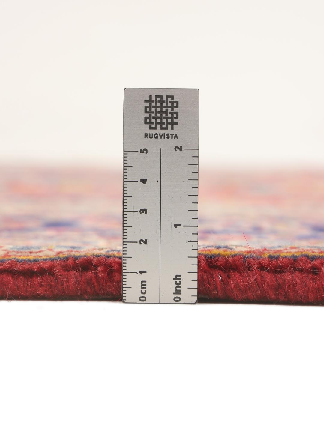 A hand-knotted Keshan rug from the Middle East with a red field and traditional floral motifs.