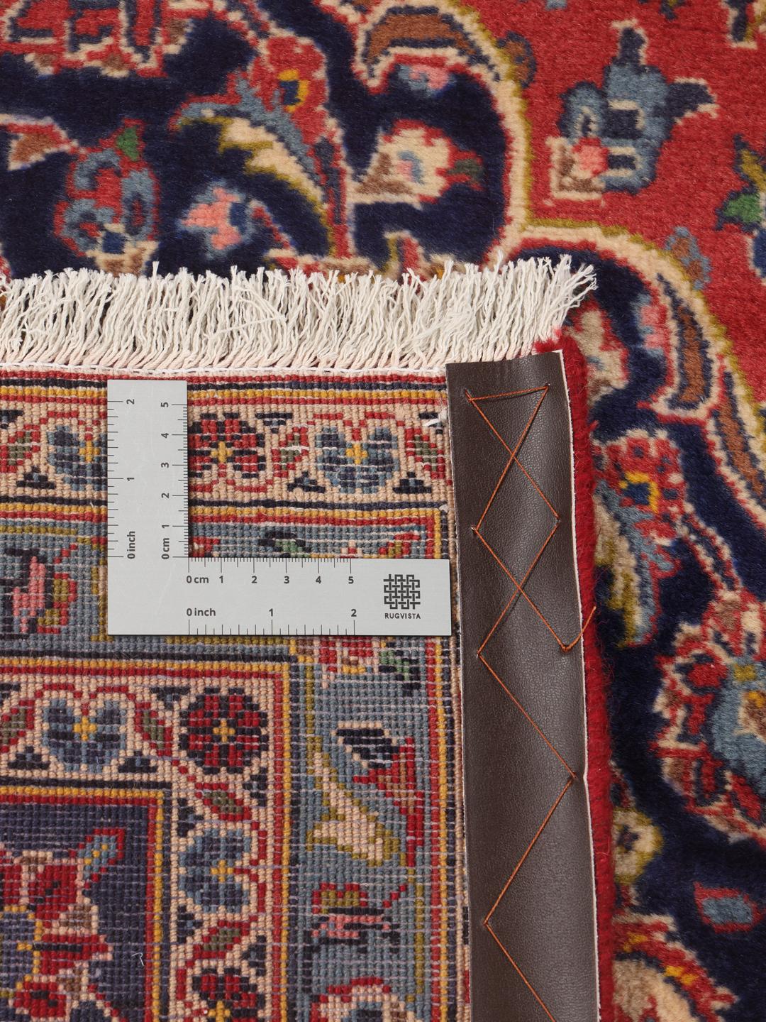 A hand-knotted Keshan rug from the Middle East with a red field and traditional floral motifs.