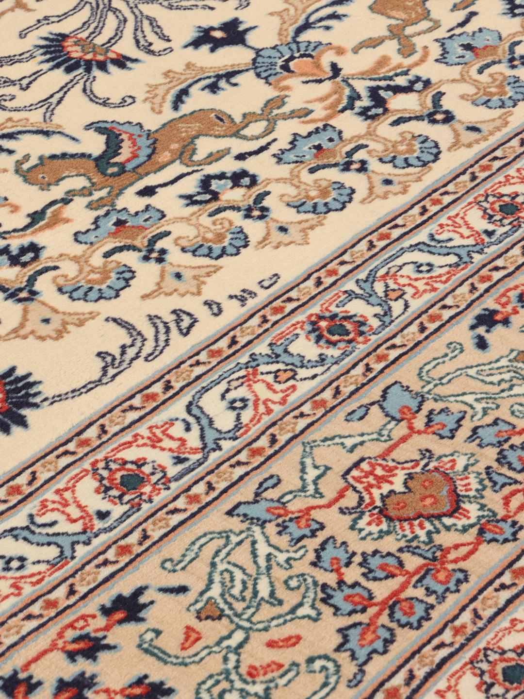 Een handgeknoopt Moud-tapijt uit het Midden-Oosten met een beige achtergrond en bloemmotieven.